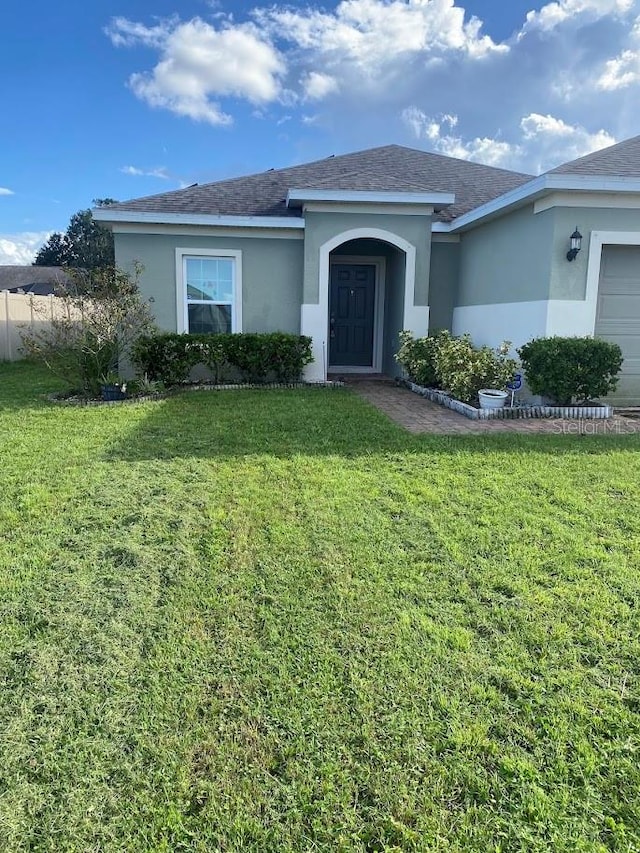 view of front of home featuring a garage and a front lawn