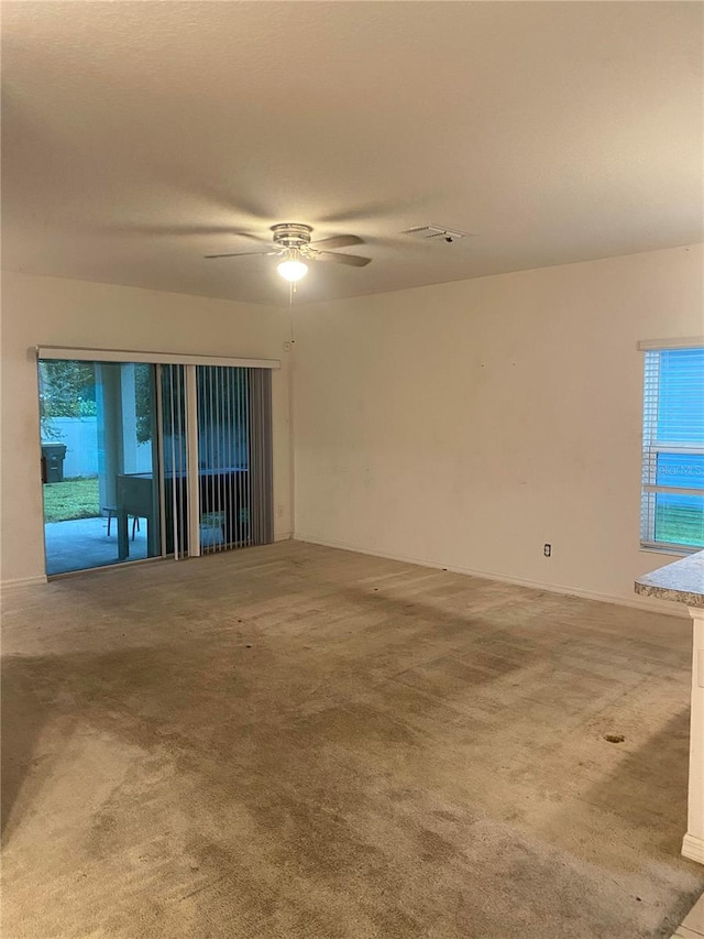 carpeted spare room featuring ceiling fan