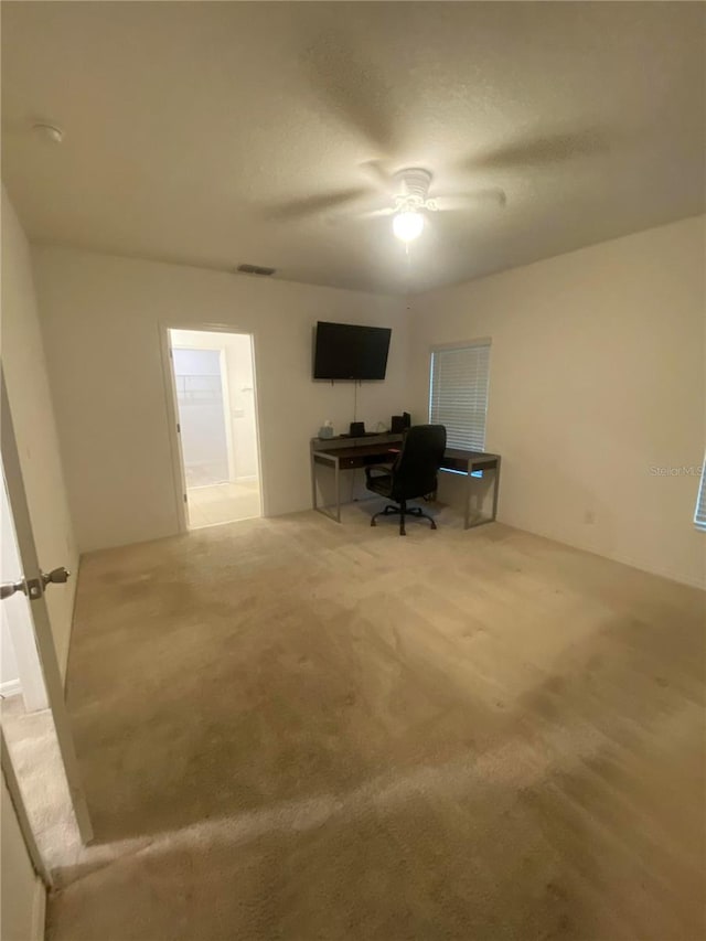 unfurnished office featuring carpet floors and ceiling fan