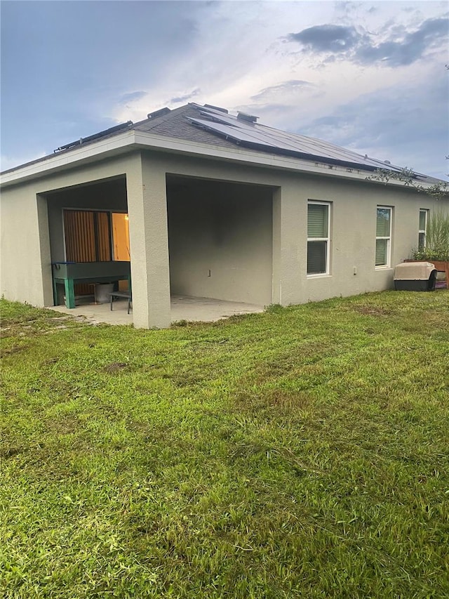 rear view of house featuring a patio area and a lawn