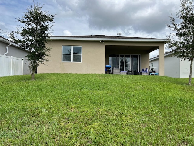 back of house featuring a lawn