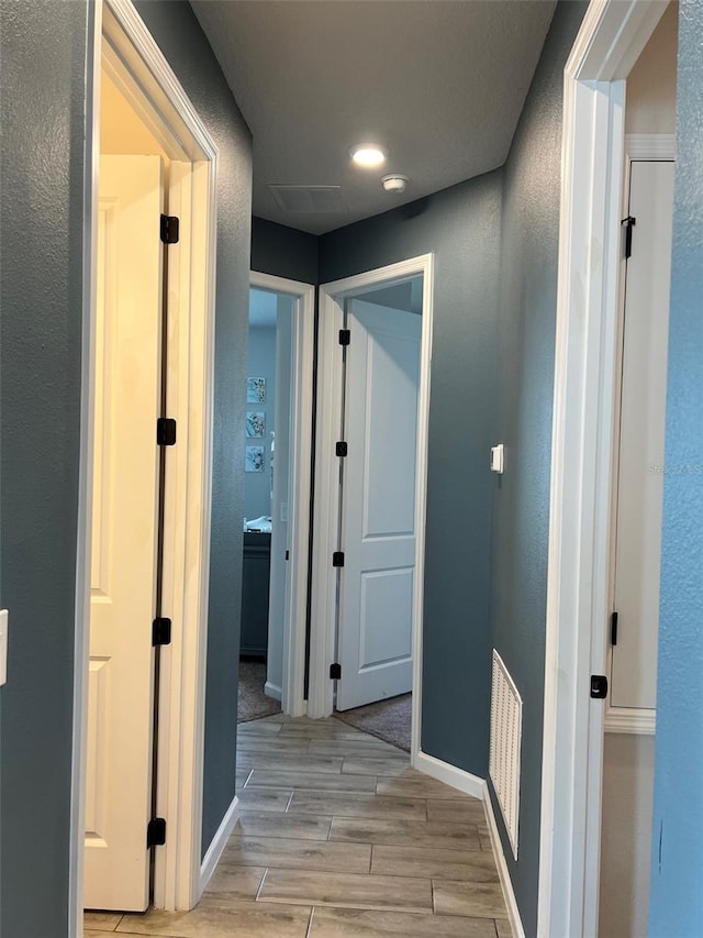 corridor with light hardwood / wood-style floors