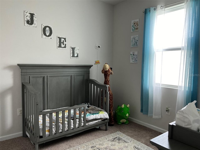 bedroom featuring a crib, carpet flooring, and multiple windows