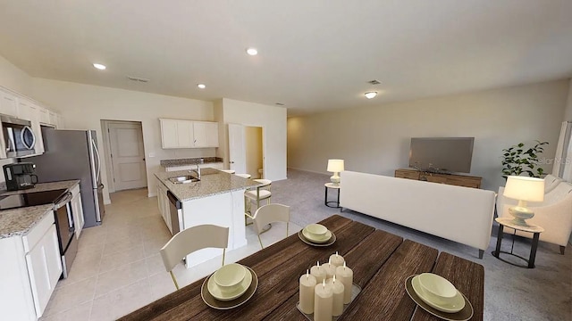 kitchen featuring an island with sink, sink, stainless steel appliances, and light stone countertops