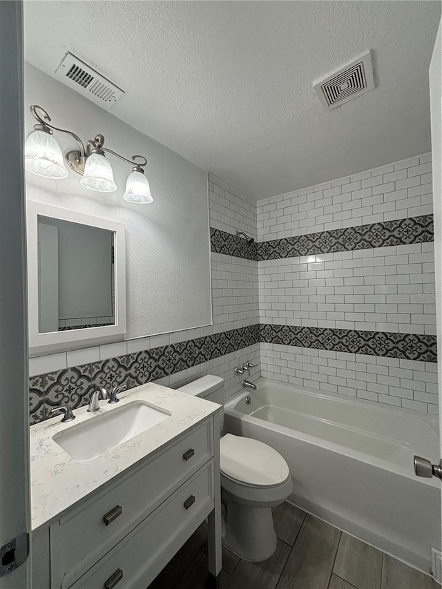 full bathroom featuring a textured ceiling, vanity, toilet, and tasteful backsplash