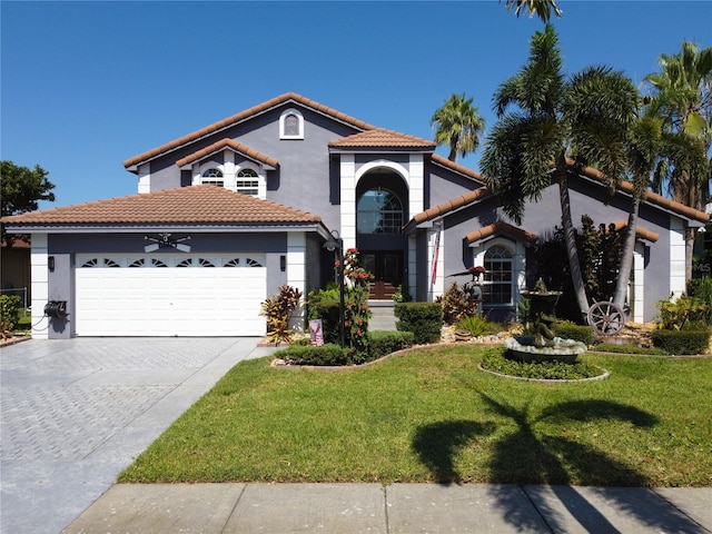 mediterranean / spanish-style house featuring a garage and a front lawn