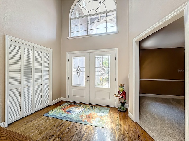 doorway to outside with a high ceiling and hardwood / wood-style floors