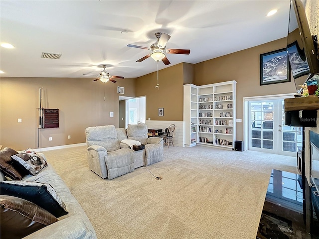 carpeted living room with ceiling fan