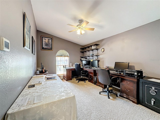 carpeted home office with lofted ceiling and ceiling fan