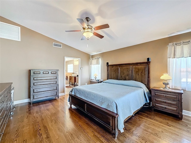 bedroom with connected bathroom, vaulted ceiling, ceiling fan, and wood-type flooring