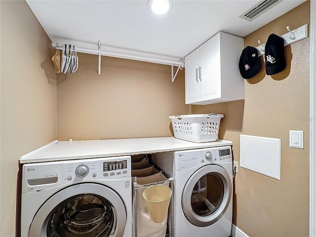 washroom with separate washer and dryer and cabinets