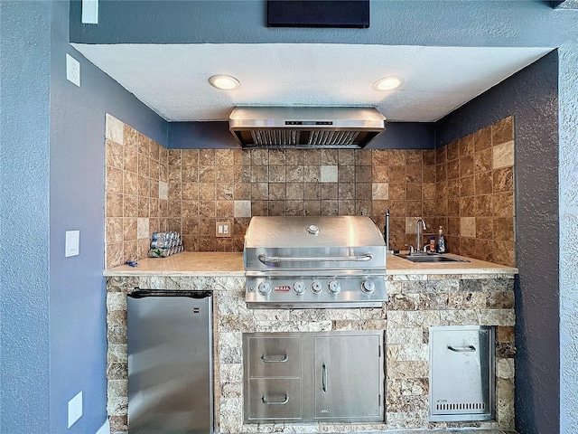 kitchen featuring sink, wall chimney range hood, decorative backsplash, fridge, and stainless steel fridge