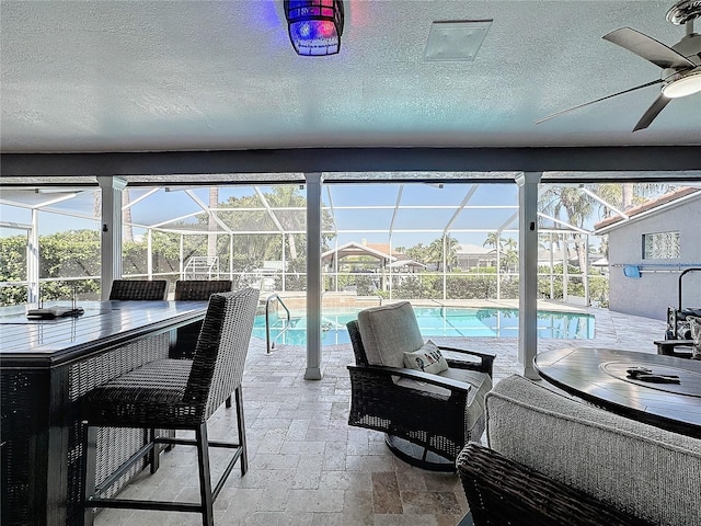 interior space with ceiling fan and a swimming pool