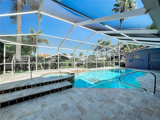 view of swimming pool with a lanai, an in ground hot tub, and a patio area