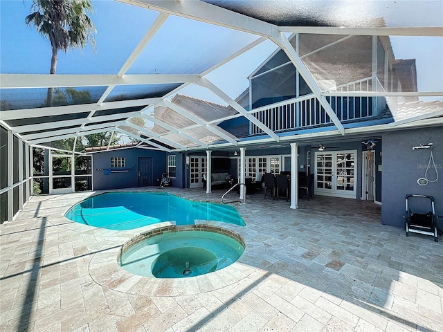 view of swimming pool with a lanai, a patio, an in ground hot tub, and french doors