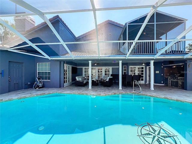 view of swimming pool featuring a patio, a lanai, outdoor lounge area, ceiling fan, and french doors