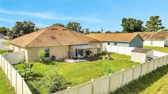 back of property with a lawn, a patio area, and a shed