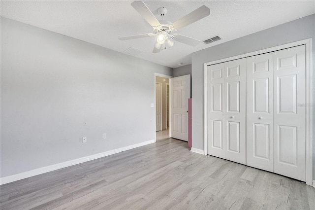 unfurnished bedroom featuring light wood-type flooring, a closet, ceiling fan, and a textured ceiling