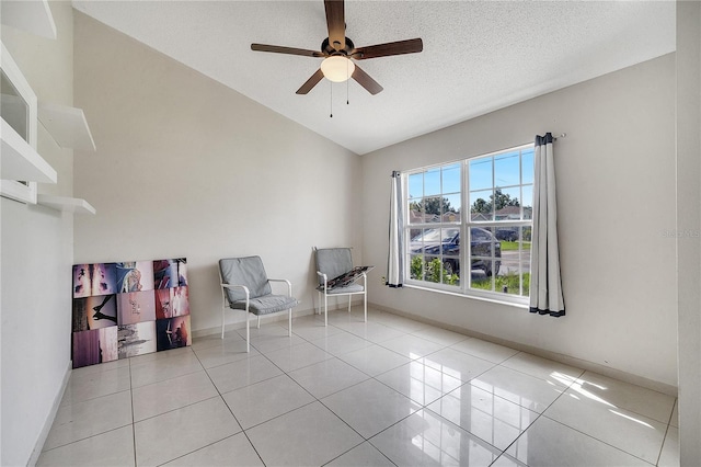 unfurnished room with a textured ceiling, ceiling fan, light tile patterned floors, and vaulted ceiling