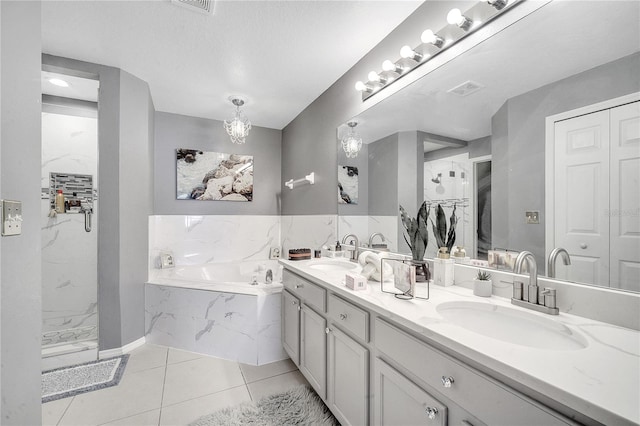 bathroom featuring plus walk in shower, tile patterned flooring, a textured ceiling, and vanity