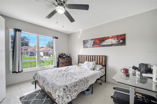 tiled bedroom with a textured ceiling and ceiling fan