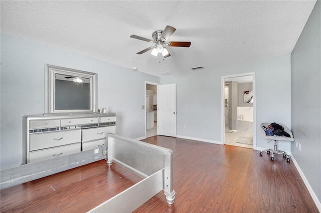 bedroom featuring ceiling fan, dark hardwood / wood-style flooring, a textured ceiling, and ensuite bath