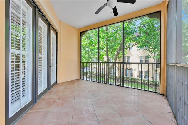 unfurnished sunroom featuring a wealth of natural light and ceiling fan