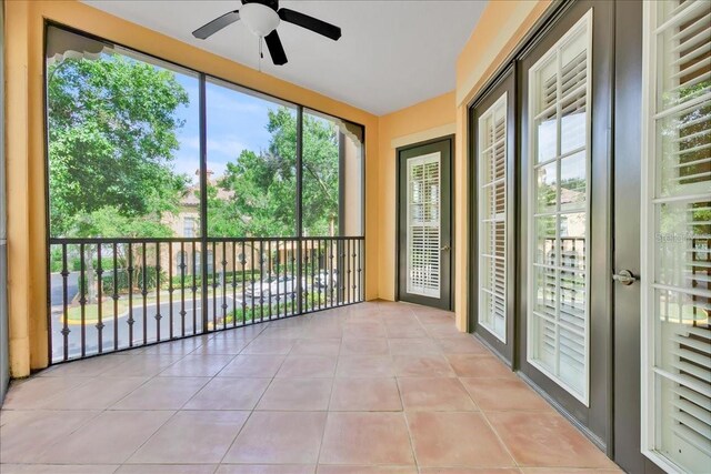 unfurnished sunroom with ceiling fan