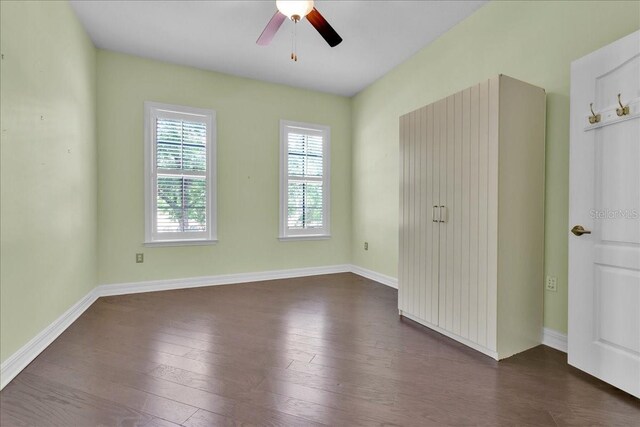 unfurnished room featuring dark wood-type flooring and ceiling fan