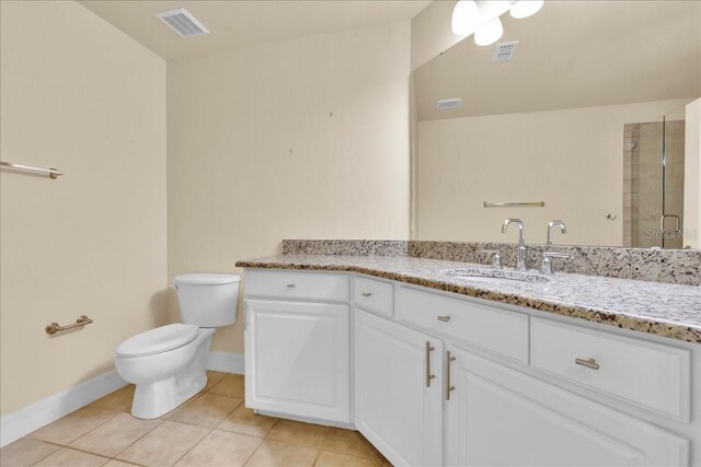 bathroom with tile patterned floors, toilet, a shower with door, and vanity