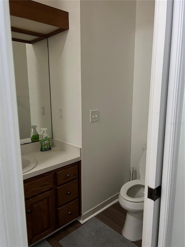 bathroom featuring vanity, toilet, and hardwood / wood-style floors