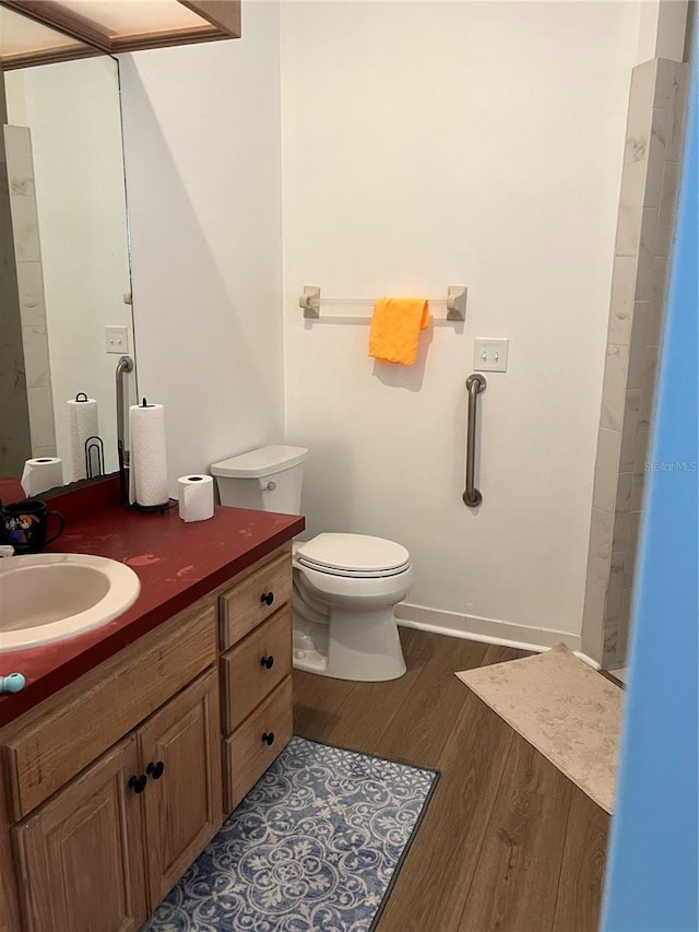 bathroom with wood-type flooring, toilet, and vanity