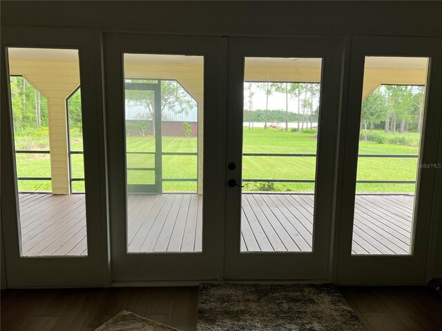 doorway to outside with a water view, dark hardwood / wood-style flooring, and french doors