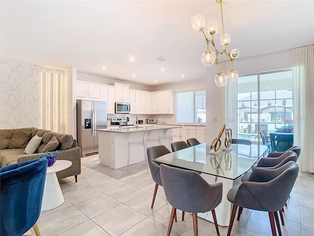 dining room featuring sink, light tile patterned floors, and a chandelier