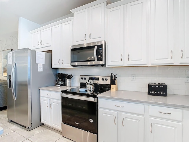 kitchen featuring appliances with stainless steel finishes, white cabinets, and light tile patterned flooring