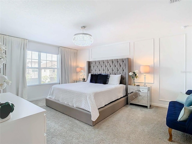 bedroom featuring light carpet and a notable chandelier