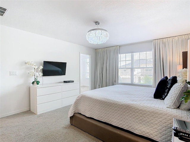 bedroom featuring an inviting chandelier and light colored carpet