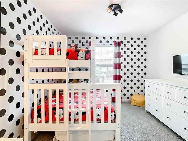 bedroom featuring a nursery area and carpet floors