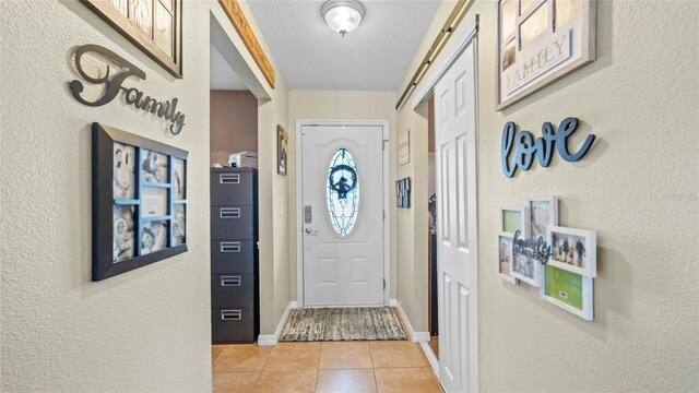 doorway featuring light tile patterned floors and a textured ceiling