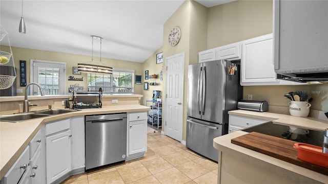 kitchen with appliances with stainless steel finishes, hanging light fixtures, sink, lofted ceiling, and white cabinets