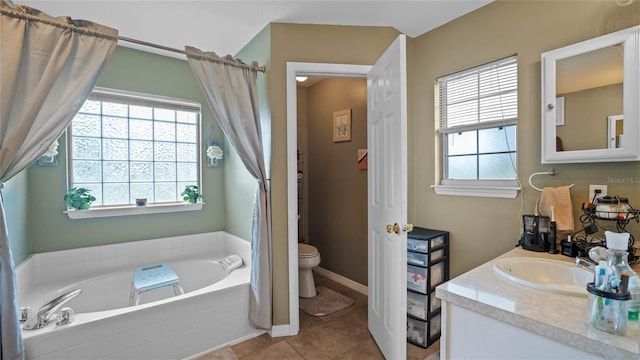 bathroom featuring tiled bath, toilet, vanity, and tile patterned floors