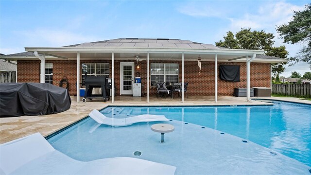 view of pool featuring a patio area, ceiling fan, and area for grilling