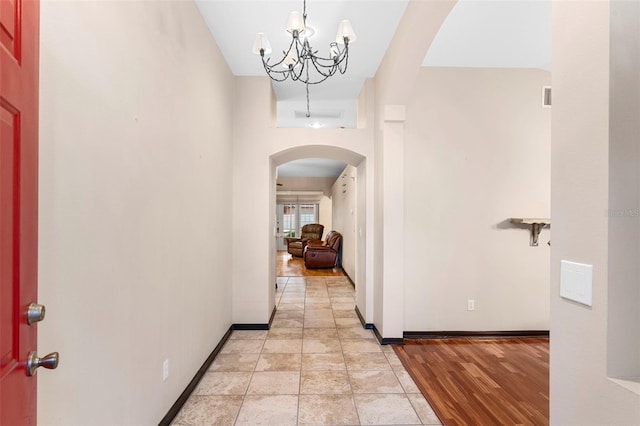 hallway featuring a chandelier and light hardwood / wood-style floors