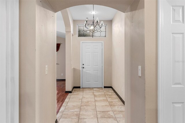 doorway with light hardwood / wood-style floors and a notable chandelier