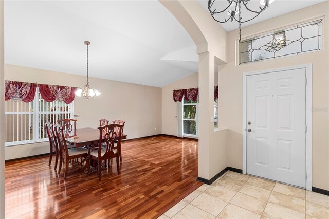 entryway with lofted ceiling, light hardwood / wood-style flooring, and a chandelier