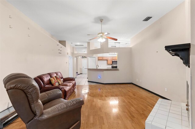 living room with light wood-type flooring and ceiling fan