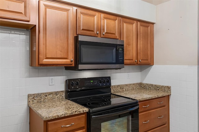 kitchen with decorative backsplash, electric range, and light stone counters