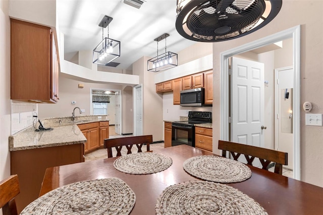 kitchen with sink, vaulted ceiling, kitchen peninsula, decorative light fixtures, and black / electric stove