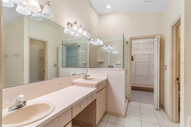 bathroom with tile patterned flooring, vanity, lofted ceiling, and a shower with shower door