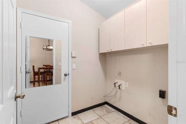 clothes washing area with washer hookup, light tile patterned floors, and cabinets